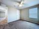 Inviting bedroom featuring plush carpet, a ceiling fan, and a large window for natural light at 7554 Wallflower Trl, Wesley Chapel, FL 33545