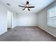 Neutral carpeted bedroom with ceiling fan and natural light from window for a cozy feel at 7554 Wallflower Trl, Wesley Chapel, FL 33545