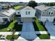 Aerial front of home featuring manicured lawn, tall palms, and spacious driveway at 7554 Wallflower Trl, Wesley Chapel, FL 33545