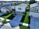 Aerial front of home featuring manicured lawn, tall palms, and spacious driveway at 7554 Wallflower Trl, Wesley Chapel, FL 33545