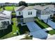 Aerial front of home featuring manicured lawn, tall palms, and spacious driveway at 7554 Wallflower Trl, Wesley Chapel, FL 33545