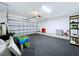 Well-lit garage featuring rubber flooring, shelving, and plenty of space for vehicles at 7554 Wallflower Trl, Wesley Chapel, FL 33545