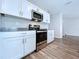 The modern kitchen is equipped with stainless steel appliances and pristine white cabinetry at 7554 Wallflower Trl, Wesley Chapel, FL 33545