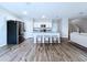 Bright kitchen boasts stainless steel appliances, white cabinetry, an island with bar seating, and wood-look floors at 7554 Wallflower Trl, Wesley Chapel, FL 33545