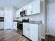 Modern kitchen showcases stainless steel appliances, white cabinets, and wood-look floors for a sleek design at 7554 Wallflower Trl, Wesley Chapel, FL 33545