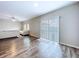Bright living room featuring sliding glass doors for ample natural light and wood-look flooring at 7554 Wallflower Trl, Wesley Chapel, FL 33545