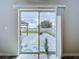 View through sliding glass door to a modern patio with pergola and an outdoor seating area at 7554 Wallflower Trl, Wesley Chapel, FL 33545