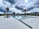 A community pool view features tropical palm trees and many lounge chairs for sunbathing at 7554 Wallflower Trl, Wesley Chapel, FL 33545
