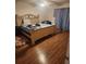 Bedroom with wood laminate flooring with a decorative rug and an ornate wooden bed frame at 8209 Chaucer Dr, Weeki Wachee, FL 34607