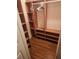 An empty walk-in closet featuring built-in shelving on wood laminate flooring at 8209 Chaucer Dr, Weeki Wachee, FL 34607