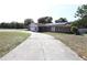 Charming home featuring stone accents, solar panels, and a long driveway leading up to the house at 8209 Chaucer Dr, Weeki Wachee, FL 34607