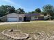 Ranch style house with solar panels, a two-car garage, and manicured lawn at 8209 Chaucer Dr, Weeki Wachee, FL 34607