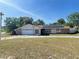Charming single-story home with stone accents, solar panels, lush greenery, and a long driveway at 8209 Chaucer Dr, Weeki Wachee, FL 34607