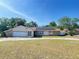 Charming single-story home with a stone-accented facade, solar panels, and well-maintained landscaping at 8209 Chaucer Dr, Weeki Wachee, FL 34607