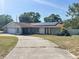 Charming home featuring stone accents, solar panels, and a long driveway leading up to the house at 8209 Chaucer Dr, Weeki Wachee, FL 34607
