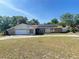 Charming single-story home with a two-car garage, solar panels, and a well-maintained lawn at 8209 Chaucer Dr, Weeki Wachee, FL 34607