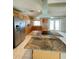 A spacious kitchen features wood cabinets, granite countertops, stainless steel appliances, and an island cooktop at 8209 Chaucer Dr, Weeki Wachee, FL 34607