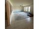 Open living room with tile and carpet flooring, large windows, and a ceiling fan at 8209 Chaucer Dr, Weeki Wachee, FL 34607