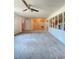 Open living room space with a ceiling fan and partial wall looking into the kitchen at 8209 Chaucer Dr, Weeki Wachee, FL 34607