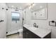 Updated bathroom features a glass enclosed shower and modern black vanity with white countertop at 911 S Florida Ave, Tarpon Springs, FL 34689