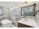 This bathroom features marble walls, a stand-alone tub, and a wooden framed mirror with a white vanity at 911 S Florida Ave, Tarpon Springs, FL 34689