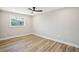 Bright bedroom featuring neutral paint, wood-look flooring and a large window at 911 S Florida Ave, Tarpon Springs, FL 34689
