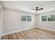 Light-filled bedroom with wood flooring, two large windows and a ceiling fan at 911 S Florida Ave, Tarpon Springs, FL 34689