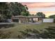 Charming single-story home features a well-manicured lawn, two palm trees, and a cozy outdoor seating area at 911 S Florida Ave, Tarpon Springs, FL 34689