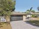 The home's exterior offers an attached garage, well-manicured lawn, cozy patio seating at 911 S Florida Ave, Tarpon Springs, FL 34689