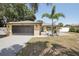 Charming exterior featuring a well-maintained lawn, inviting entrance, and a two-car garage at 911 S Florida Ave, Tarpon Springs, FL 34689