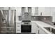 Well-equipped kitchen with stainless steel appliances, white cabinets, and gray backsplash at 911 S Florida Ave, Tarpon Springs, FL 34689