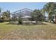 This home features a large screened pool enclosure with a view of the fenced back yard at 911 S Florida Ave, Tarpon Springs, FL 34689