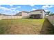 Expansive backyard featuring a well-kept lawn, bordered by a fence and offering ample space for recreation at 9640 Lemon Drop Loop, Ruskin, FL 33573