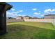 Large backyard with a well-maintained lawn, surrounded by a tall privacy fence and neighborhood views at 9640 Lemon Drop Loop, Ruskin, FL 33573