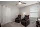 This bedroom includes two recliners, neutral walls, a ceiling fan, and is brightly lit at 9640 Lemon Drop Loop, Ruskin, FL 33573