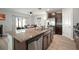 Kitchen island features stainless steel appliances, dark cabinets, and an adjacent dining area with natural light at 9640 Lemon Drop Loop, Ruskin, FL 33573