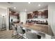 Kitchen with a granite island, stainless steel appliances, dark cabinets, and modern lighting at 9640 Lemon Drop Loop, Ruskin, FL 33573