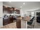 Open-concept kitchen with dark wood cabinets, stainless steel appliances, and a granite island with bar seating at 9640 Lemon Drop Loop, Ruskin, FL 33573