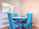 Close-up view of the round dining table in a coastal style with blue chairs, complementing the space at 1100 East Bay Dr # 42, Largo, FL 33770