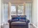 Cozy sitting area with loveseat, beach-themed pillows and curtains, and ample natural light at 1100 East Bay Dr # 42, Largo, FL 33770