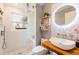 Modern bathroom with glass shower, unique pebble-tiled wall, and a stylish vessel sink on a wood counter at 11104 Taft Dr, Port Richey, FL 34668