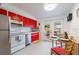 Bright kitchen featuring red cabinets, stainless steel appliances, and tile flooring at 11104 Taft Dr, Port Richey, FL 34668