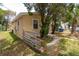 Tan home featuring wood panels and stucco walls with a simple fenced yard and mature trees at 1142 7Th Nw St, Largo, FL 33770