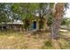 Charming home with blue door and a small fenced yard and palm tree at 1142 7Th Nw St, Largo, FL 33770
