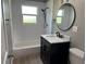 Modern bathroom featuring a sleek vanity, subway tile surround, and a stylish round mirror at 11729 John Robbins Rd, Riverview, FL 33578