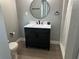 Modern bathroom featuring a sleek vanity, round mirror, and a shower with a curtain at 11729 John Robbins Rd, Riverview, FL 33578