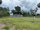 Charming single-Gathering home with a screened porch, a large yard, and a white fence at 11729 John Robbins Rd, Riverview, FL 33578