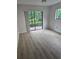 Bright bedroom with sliding glass doors and laminate flooring, leading to outdoor space at 11802 Raintree Lake Ln # B, Temple Terrace, FL 33617
