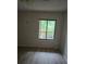 Bedroom with neutral walls, wood-look floors, and window view overlooking lush outdoor foliage at 11802 Raintree Lake Ln # B, Temple Terrace, FL 33617