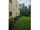 Exterior shot of the building's side with well-maintained green lawn and tidy shrubbery at 11802 Raintree Lake Ln # B, Temple Terrace, FL 33617